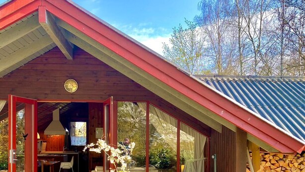 A wooden deck with a dining table and chairs, a covered patio area, and a view of the surrounding landscape. - Holidays with child and dog in Gartow am See (Gartow)