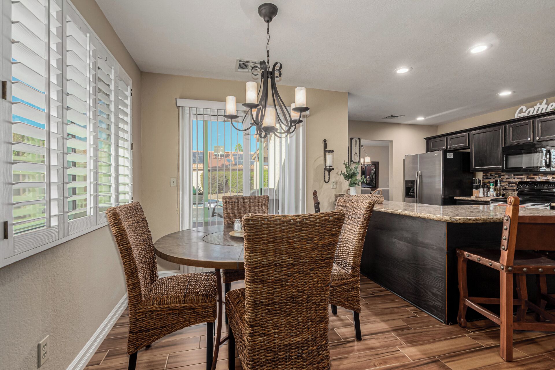 A modern kitchen with dark cabinetry, a stainless steel refrigerator, and a built-in oven.
