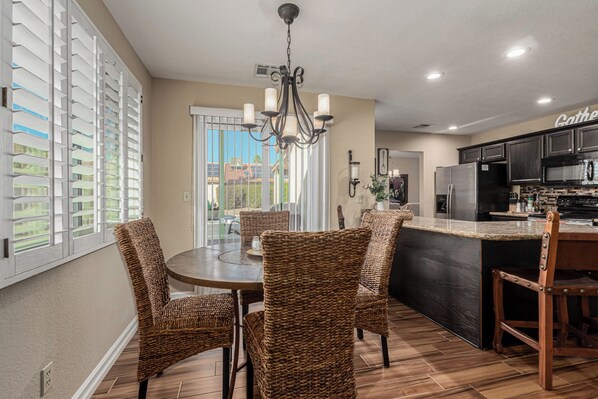 A modern kitchen with dark cabinetry, a stainless steel refrigerator, and a built-in oven.