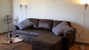 Ein Wohnzimmer mit einer Couch, einem Beistelltisch und zwei Stehlampen.