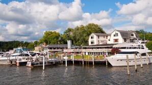 A marina with docked boats, a waterfront building, and a dock extending into the water.