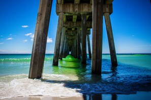 A pier extending into calm waters with clear skies.
