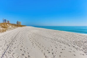 Na praia, espreguiçadeiras, toalhas de praia 