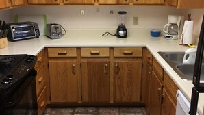 A kitchen with wooden cabinets, a toaster, a blender, a coffee maker, and a dishwasher. - Sedona Red Rock Private Casita (sedona)