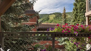 Un balcon avec vue sur une piscine et un paysage montagneux.