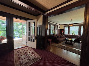 A spacious living room with a large sofa, a coffee table, and a view of the outdoors through large windows.