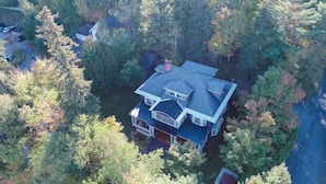 An aerial view of a house surrounded by dense trees.