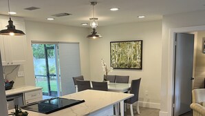 A modern kitchen with a central island, bar stools, and a dining area. -  4 Bed pool House by Bay!  Lido & Siesta Key Beaches very close  (Sarasota)