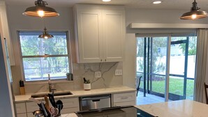A modern kitchen with a large island, white cabinets, and pendant lighting. -  4 Bed pool House by Bay!  Lido & Siesta Key Beaches very close  (Sarasota)