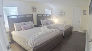 Camera da letto con due letti, testiere in legno e un piccolo addorno a parete.