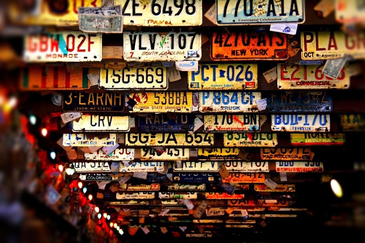 A wall of various license plates from different states and years.