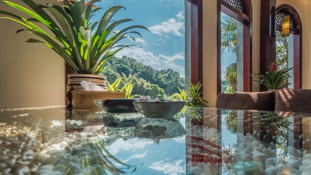 A glass table with a clear view of a lush garden and a wooden structure through the glass. - Siqi Inn (Baoshan)