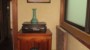 A wooden cabinet with a vintage radio, a framed picture, and a fire extinguisher.