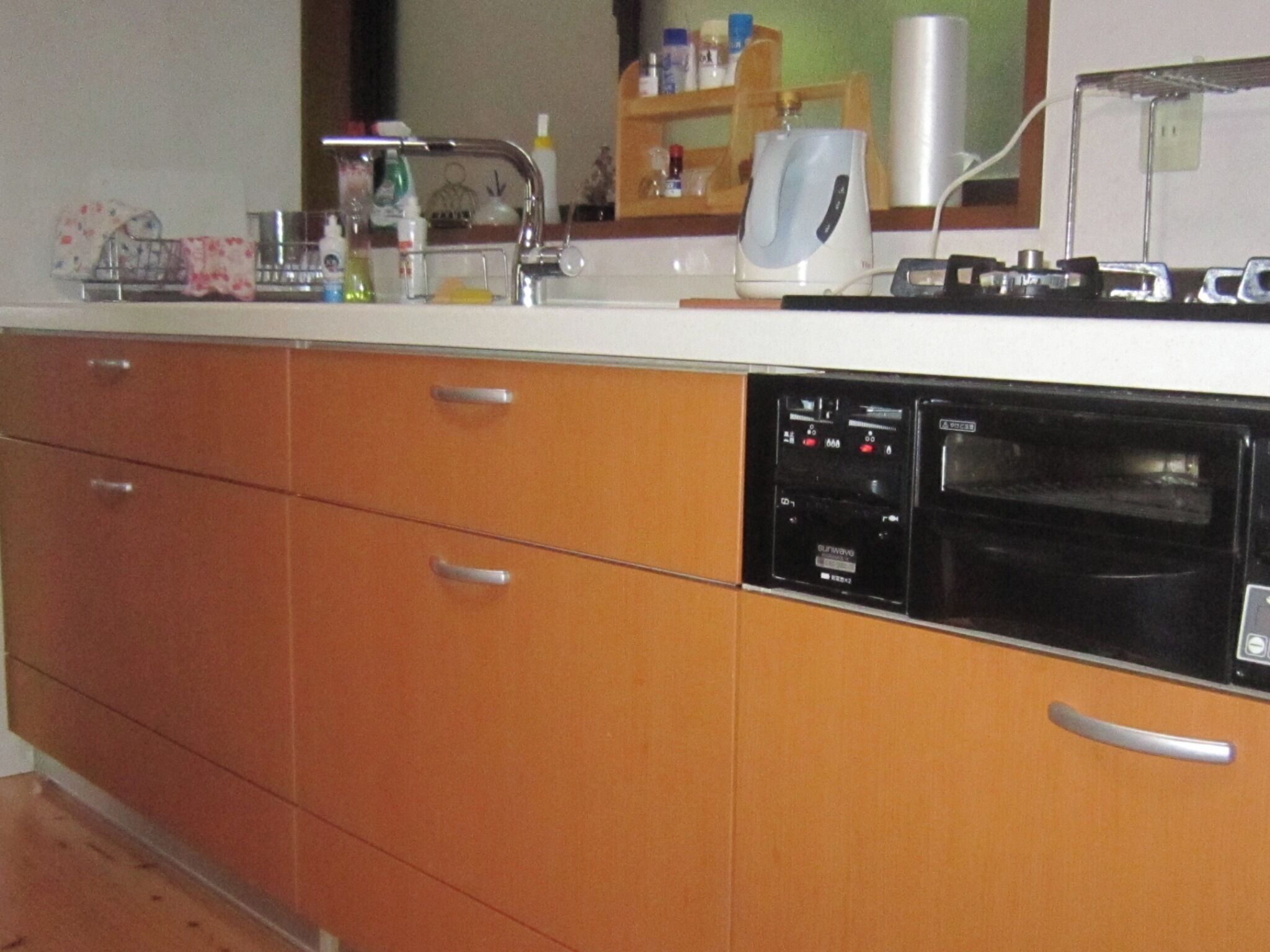 Una cocina con armarios de madera, lavavajillas, cafetera y microondas.