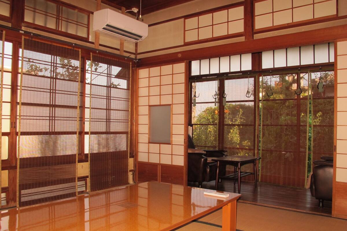 Una habitación japonesa tradicional con suelo de tatami, puertas correderas shoji y una mesa de madera baja.