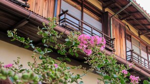 A traditional wooden building with balconies and pink flowering plants. - Atami Ikkyuan (Atami)
