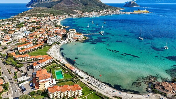 A coastal town with a marina, clear blue waters, and mountainous backdrop. - Beautiful  villa for 8 people with A/C, private pool, TV and patio (Olbia)