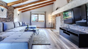 A modern living room with a sectional sofa, a flat-screen TV, and a stone fireplace. - Beautiful  villa for 8 people with A/C, private pool, WIFI, TV and terrace (Umag)