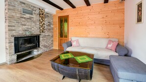 A cozy living room with a stone fireplace, wooden ceiling beams, a sofa, and a coffee table. - Beautiful private villa for 6 guests with WIFI, private pool, A/C, TV, terrace and panoramic view (Brod Na Kupi)