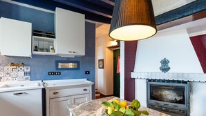A kitchen with white cabinets, a marble countertop, and a hanging light fixture.