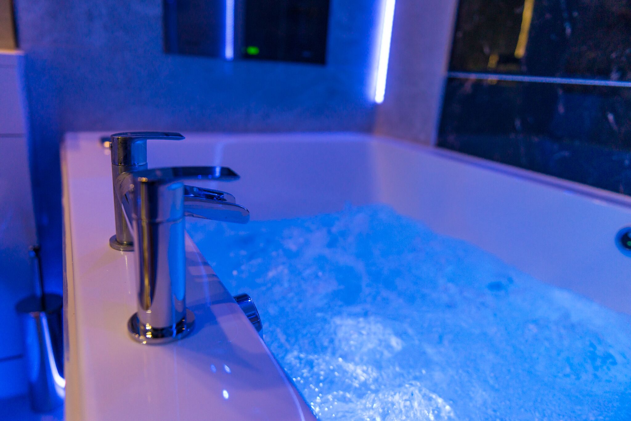 A bathtub with a modern faucet and a window in the background.