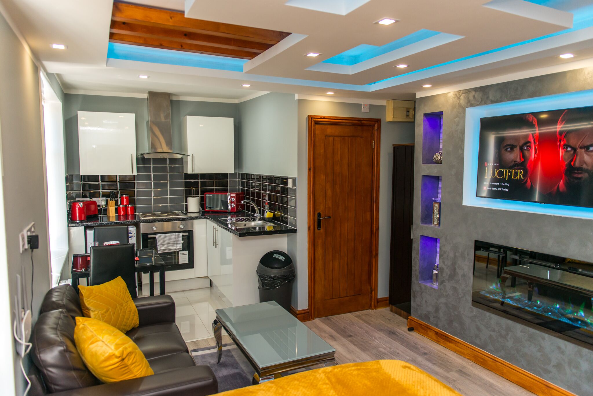 A modern living room with a sofa, coffee table, and a TV mounted on the wall.