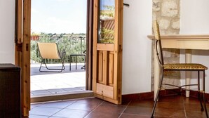 A room with a wooden door leading to an outdoor balcony with a chair and a table. - Stunning private villa for 16 people with WIFI, hot tub, private pool, A/C, TV and patio (Modica)