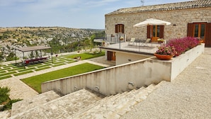 A stone building with a balcony, outdoor seating, and a view of the countryside. - Stunning private villa for 16 people with WIFI, hot tub, private pool, A/C, TV and patio (Modica)