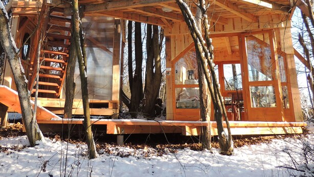 A wooden cabin with a balcony, a spiral staircase, and a large window. - Kerca Bio Farm (Kercaszomor)