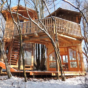 A wooden cabin with a balcony, a spiral staircase, and a large window. - Kerca Bio Farm (Kercaszomor)