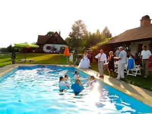 Una piscina al aire libre, sillones reclinables de piscina