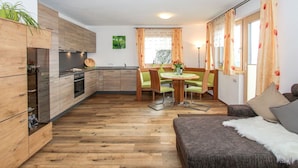 A compact living space with a kitchenette, dining area, and seating area. - Beautiful apartment for 6 people with WIFI, TV, patio and panoramic view (Mitterdorf)