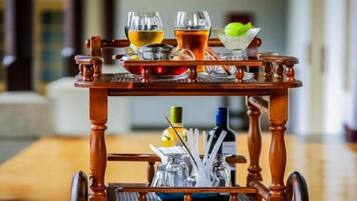 A wooden trolley with a tray table, glasses, and bottles, likely for serving drinks.