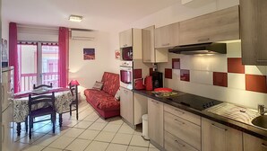 Cocina compacta con comedor, sofá y pequeña mesa.
