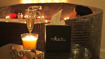 Un coin bar avec une bougie, une coupe de champagne et une boîte de mouchoirs portant l’inscription « The Talbot Hotel ».