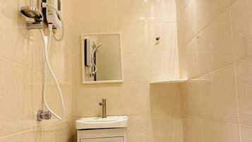 A bathroom with a shower, a sink, and a mirror.