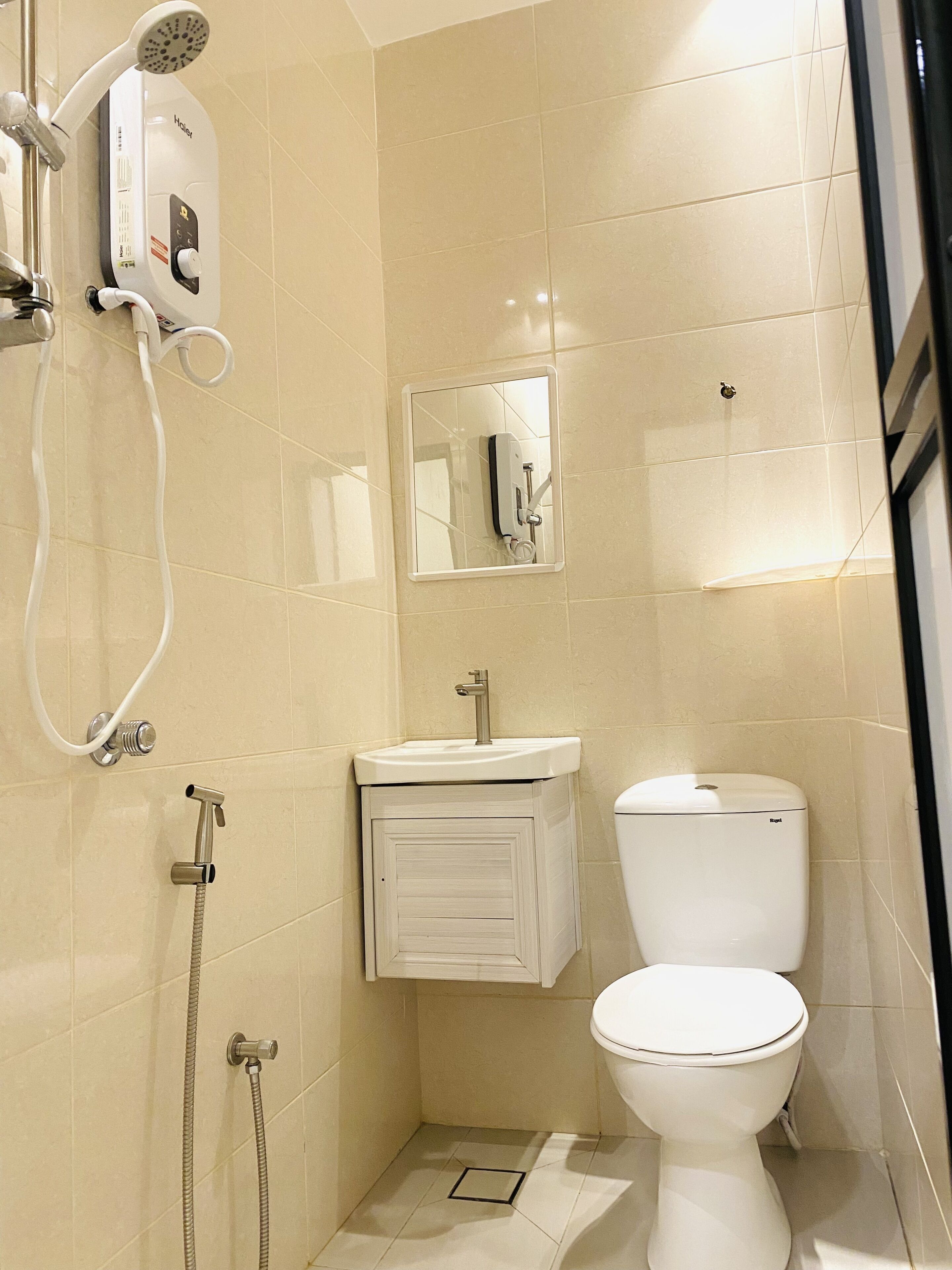 A bathroom with a toilet, sink, and shower unit.