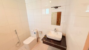 A bathroom with a toilet, a sink, and a shower. - Hotel Little Buddha (Lumbini)