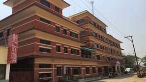 A multi-story building with a sign reading "Asia Kitchen" on the left side. - Hotel Little Buddha (Lumbini)