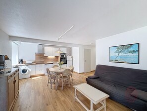 Un appartement moderne comprenant une cuisine, un coin repas et un salon.