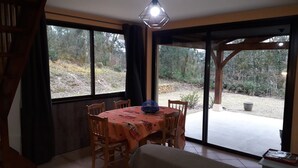 Un comedor con una mesa y sillas, un ventanal grande y vistas al exterior.