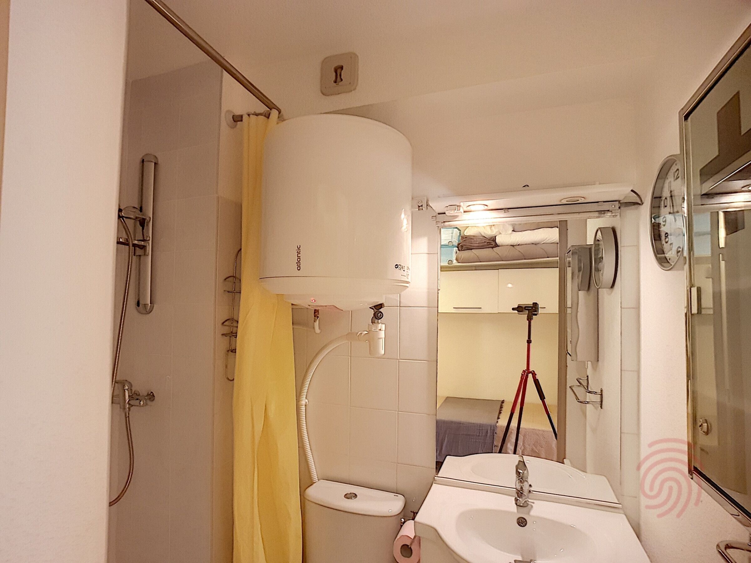 A compact bathroom with a shower, toilet, and sink.