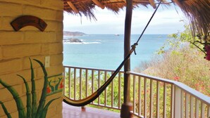 A hammock on a balcony with a view of the ocean and a thatched roof structure. - Altamira Mazunte (Santa María Tonameca)