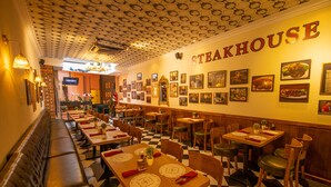 A restaurant interior with a checkered floor, wooden tables, and benches. - Reunion Residence (George Town)