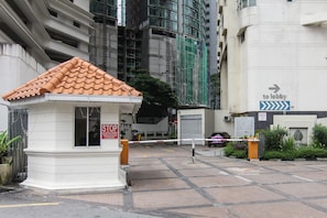 A gated entrance with a stop sign, a directional sign to the lobby, and a building under construction in the background. - Parkview Residence Kuala Lumpur (Kuala Lumpur)