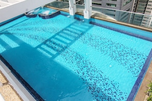 A swimming pool with clear blue water, a tiled edge, and a glass balustrade. - Parkview Residence Kuala Lumpur (Kuala Lumpur)