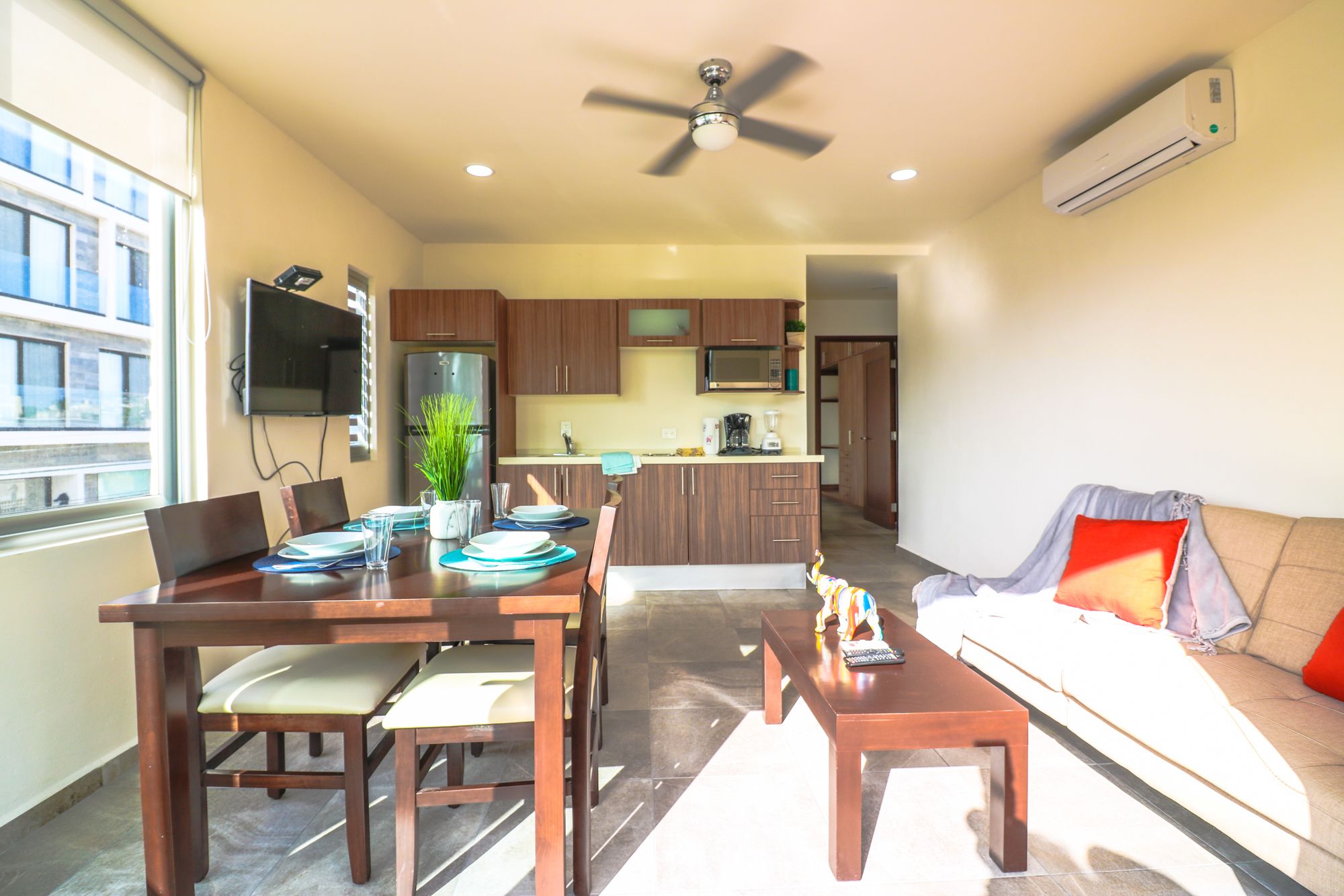 A modern apartment with a dining area, kitchen, and living room.