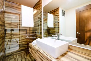 A modern bathroom with a large mirror, a white sink, and a shower area. - The Furlough Fur303 (Playa del Carmen)