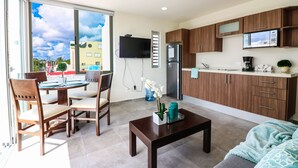 A modern apartment with a dining area, kitchen, and living room. - The Furlough Fur304 (Playa del Carmen)