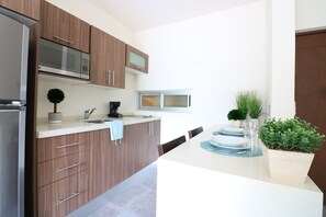 Appartement | Privékeuken | Een koelkast met diepvriezer, een microgolfoven, een kookplaat